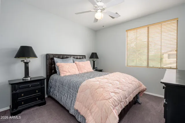 a bedroom with bed and a flat tv screen on dresser