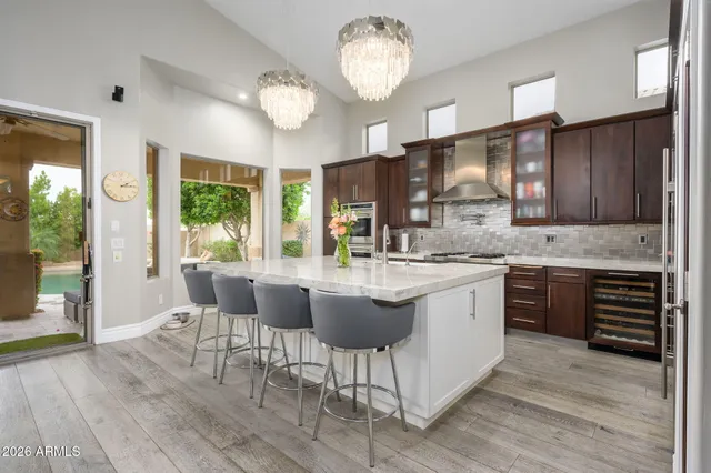 a kitchen with a dining table chairs cabinets and stainless steel appliances