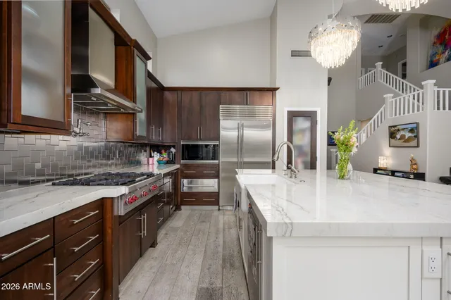 a kitchen with stainless steel appliances granite countertop a sink a stove and a refrigerator