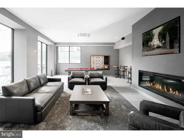 a living room with furniture a rug a large window and a flat screen tv