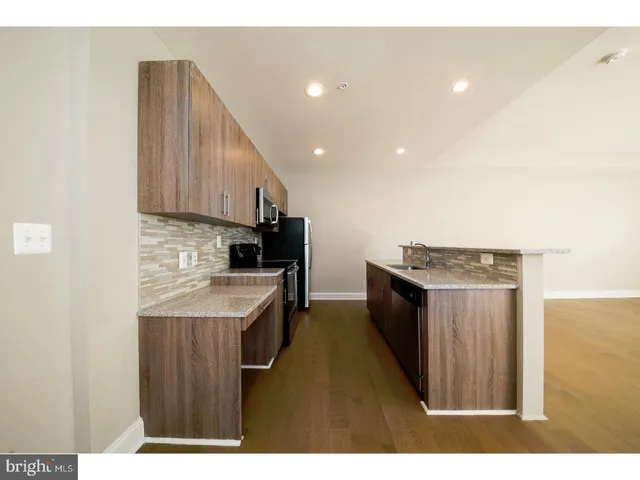 a kitchen with stainless steel appliances granite countertop a sink a stove and a refrigerator