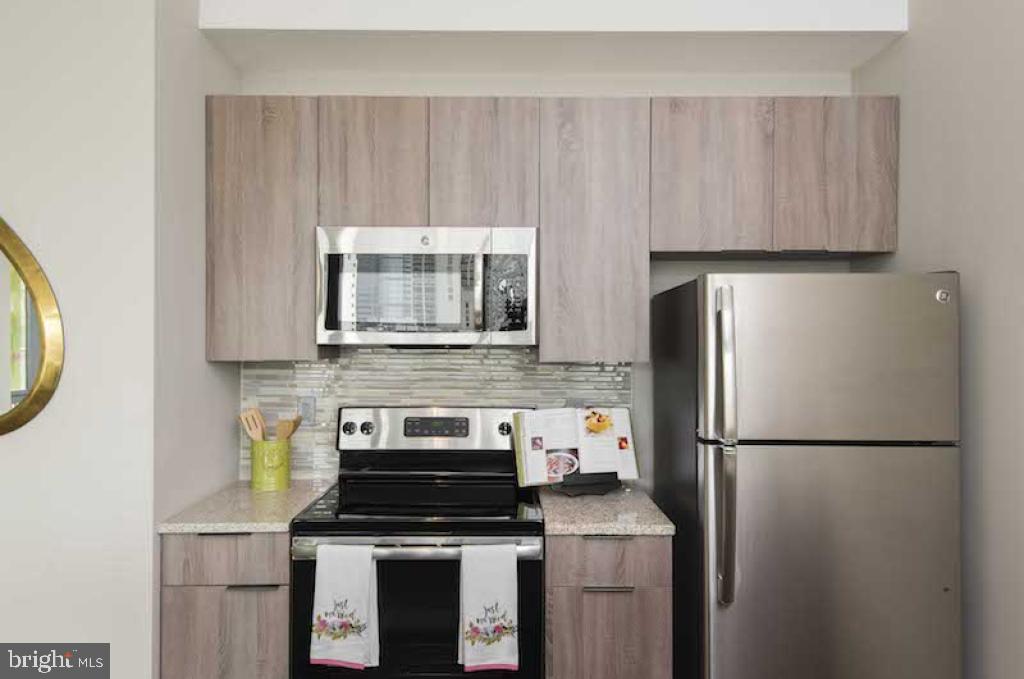 218-26 Arch Street, Unit 511 Philadelphia, PA 19106 - Photo 29 of 37 a kitchen with a stove a refrigerator and a microwave