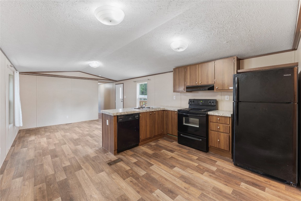21504 Mexican John Road, Unit B New Caney, TX 77357 - Photo 11 of 13 a kitchen with a refrigerator and a stove top oven