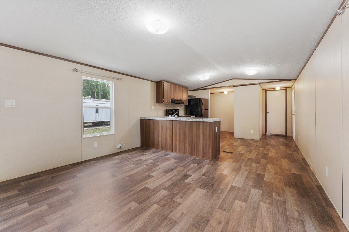 21504 Mexican John Road, Unit B New Caney, TX 77357 - Photo 2 of 13 a view of a kitchen with wooden floor and a window