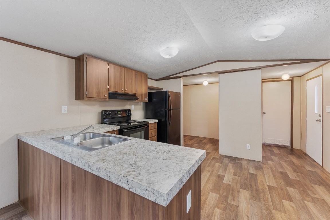 21504 Mexican John Road, Unit B New Caney, TX 77357 - Photo 3 of 13 a kitchen with granite countertop a sink a stove and refrigerator