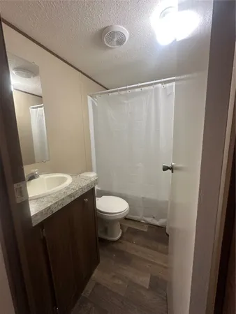 a bathroom with a granite countertop sink toilet and shower