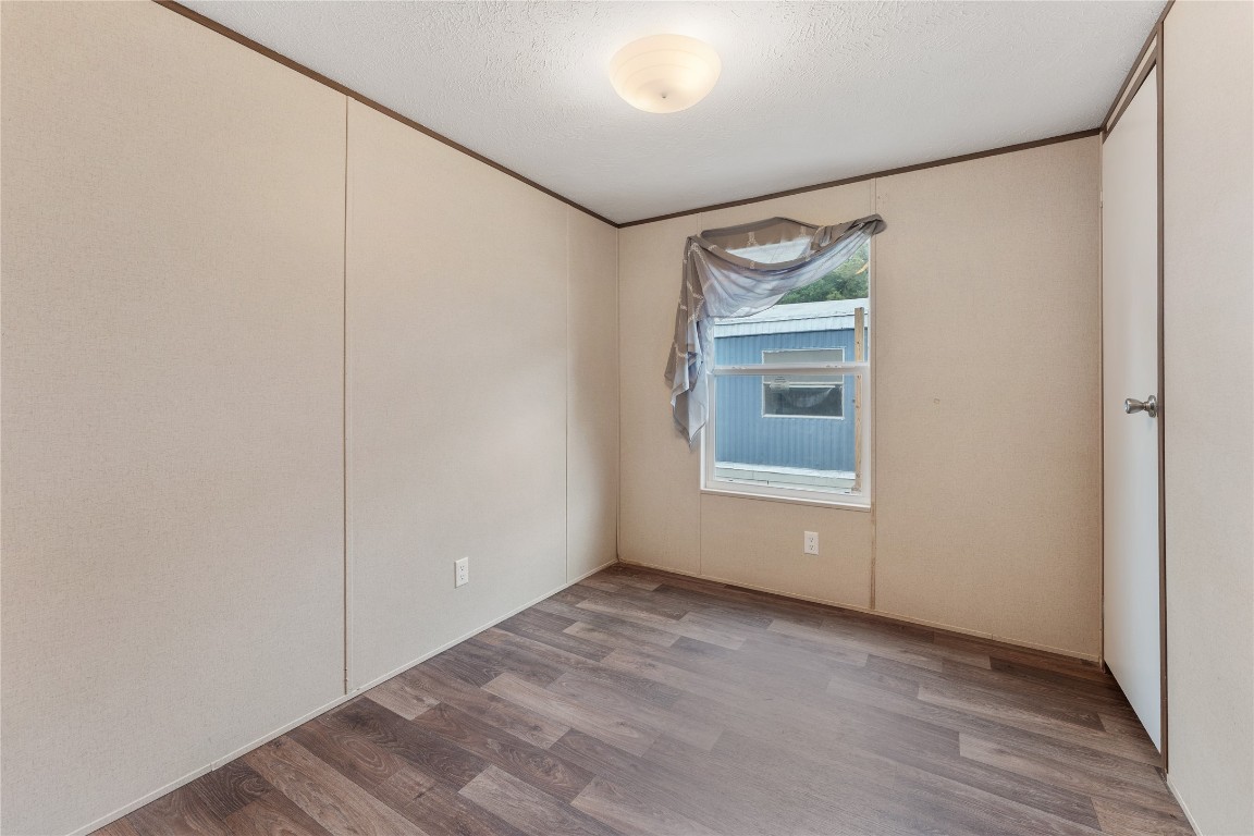 21504 Mexican John Road, Unit B New Caney, TX 77357 - Photo 8 of 13 a view of an empty room with wooden floor and a window