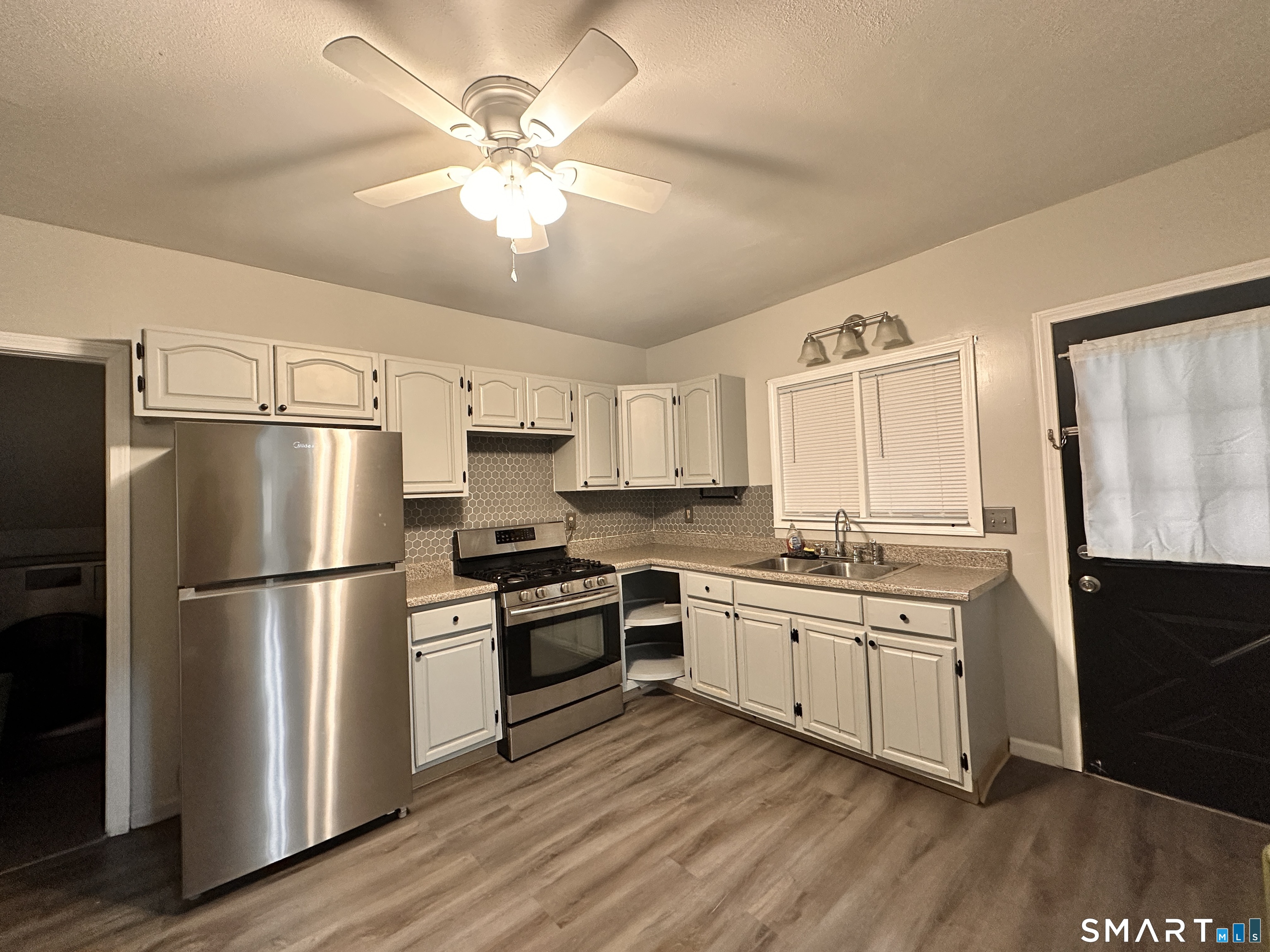 74 Mt Pleasant Street, Unit 2 Derby, CT 06418 - Photo 4 of 19 a kitchen with a sink stainless steel appliances and wooden floor