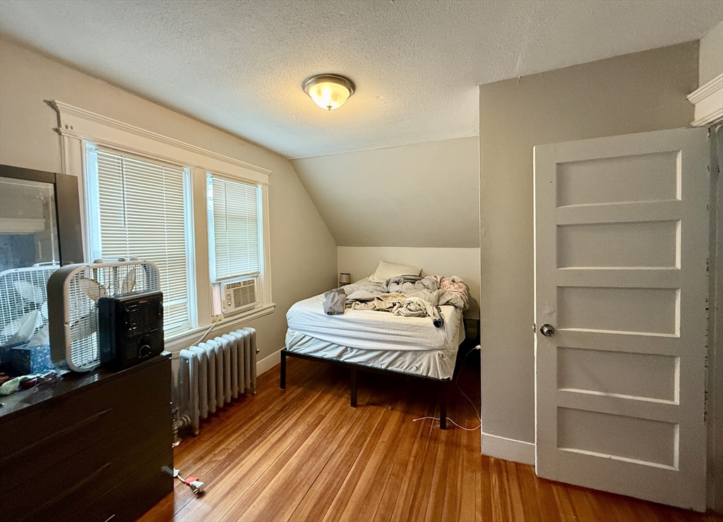 63 Langdon Street Springfield, MA 01104 - Photo 12 of 22 a bedroom with a bed and wooden floor