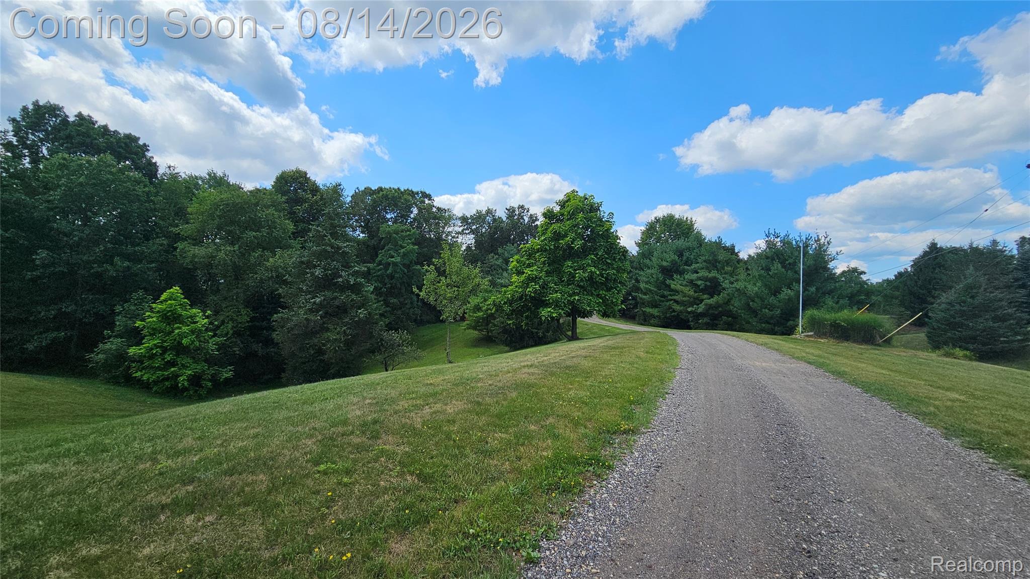 7966 Pettysville Road Pinckney, MI 48169 - Photo 2 of 43 Gravel pathway bordered by grassy slopes and mature trees