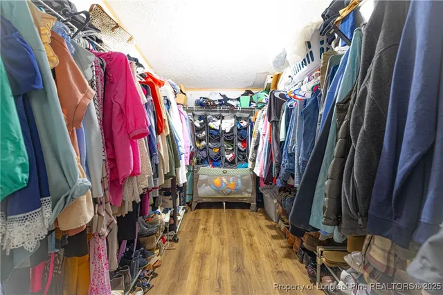 a view of walk in closet with clothes