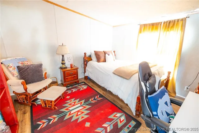 a bedroom with two beds and wooden floor