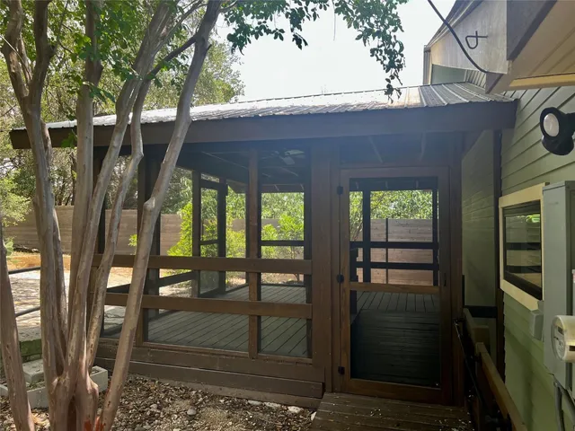 a backyard of a house with large tree and wooden fence