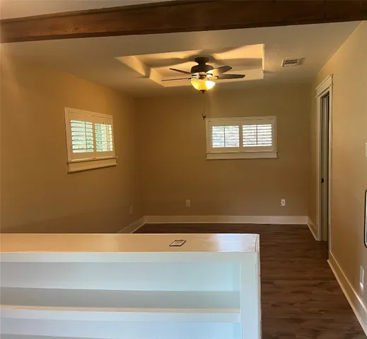 a view of a small space with wooden floor and a window