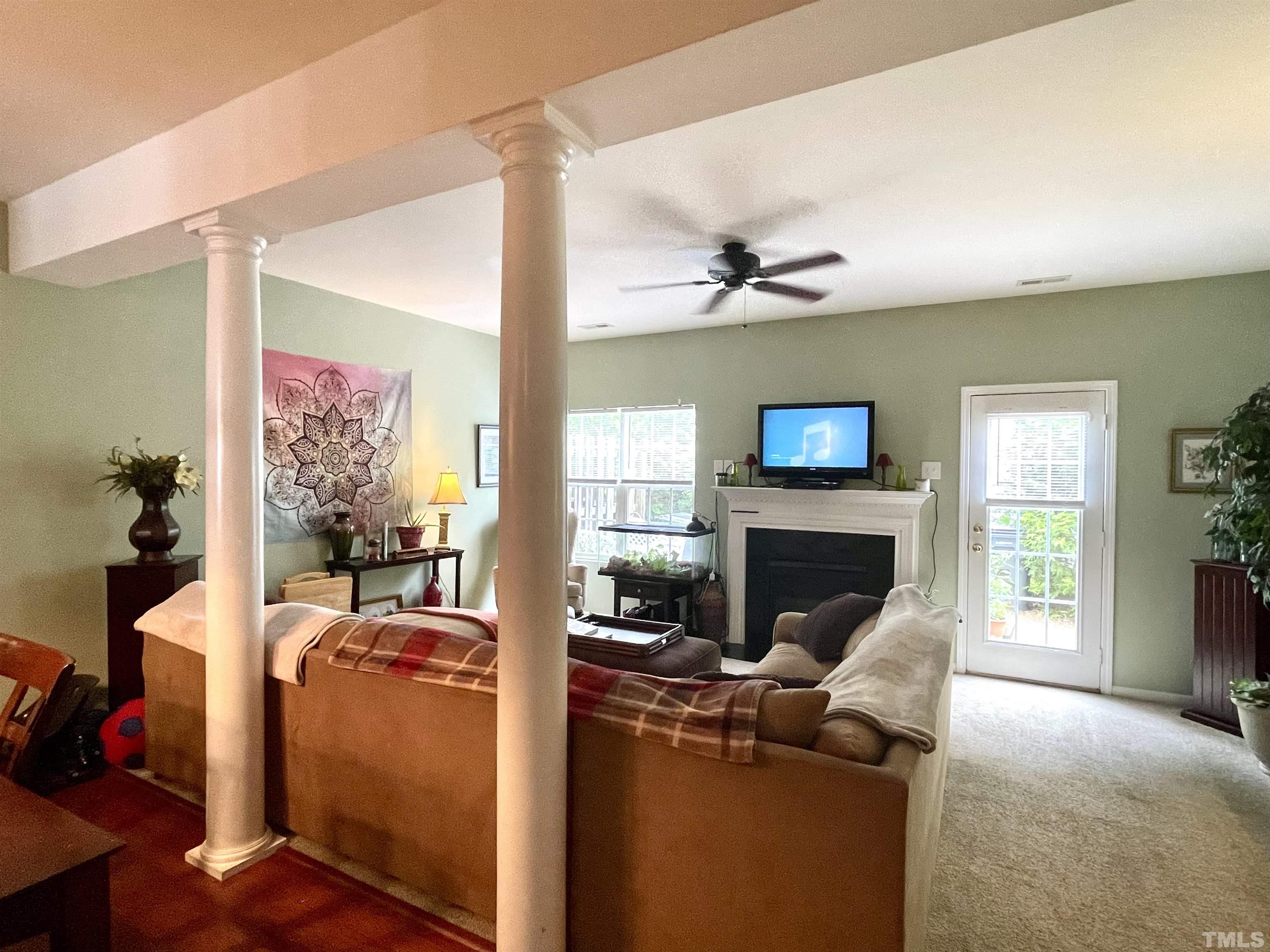 113 Graystar Road Apex, NC 27502 - Photo 7 of 24 a living room with furniture a flat screen tv and a fireplace