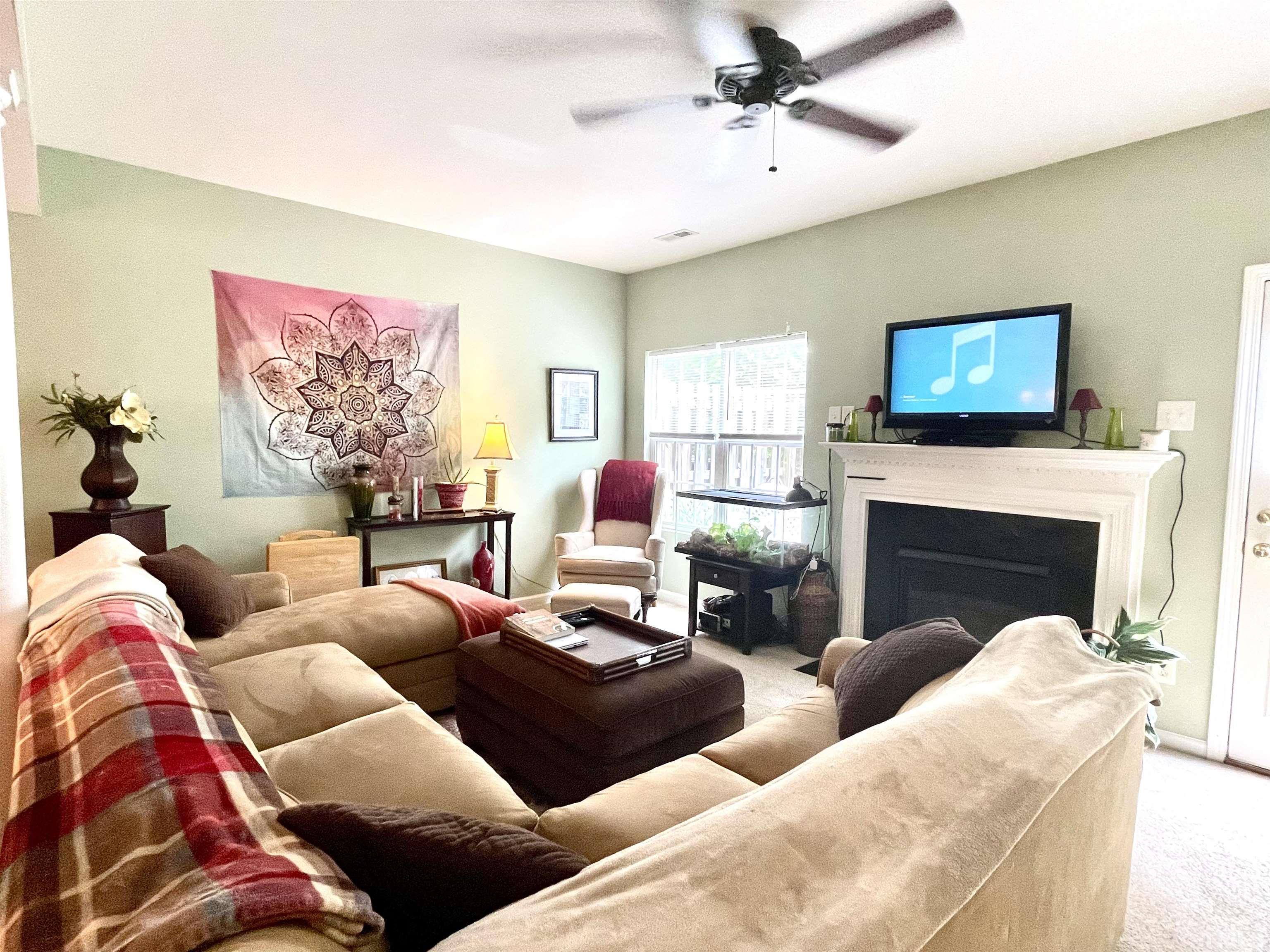 113 Graystar Road Apex, NC 27502 - Photo 10 of 24 a living room with furniture a fireplace and a flat screen tv