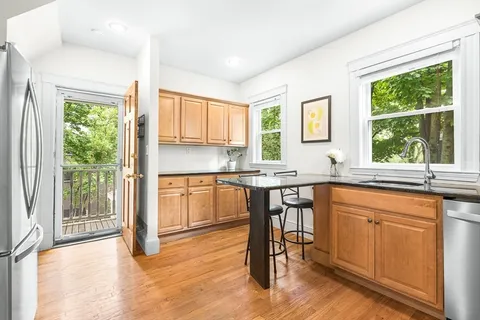 a kitchen with a sink appliances cabinets and dining table
