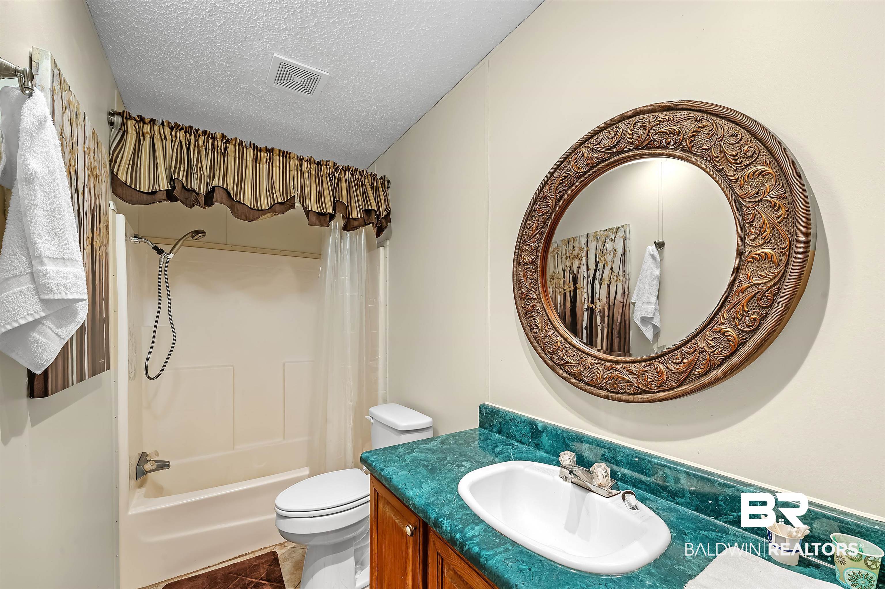 10970 Stucki Road Elberta, AL 36530 - Photo 34 of 56 Full bathroom featuring tile patterned flooring, a textured ceiling, toilet, vanity, and shower / bath combo