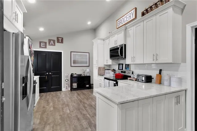 a living room with furniture a flat screen tv and a chandelier