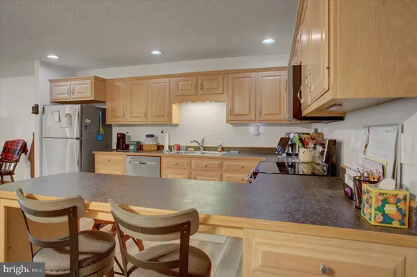 a kitchen with stainless steel appliances granite countertop a refrigerator and microwave