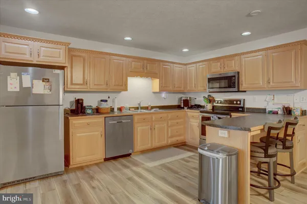 a kitchen with granite countertop a refrigerator stove top oven and sink