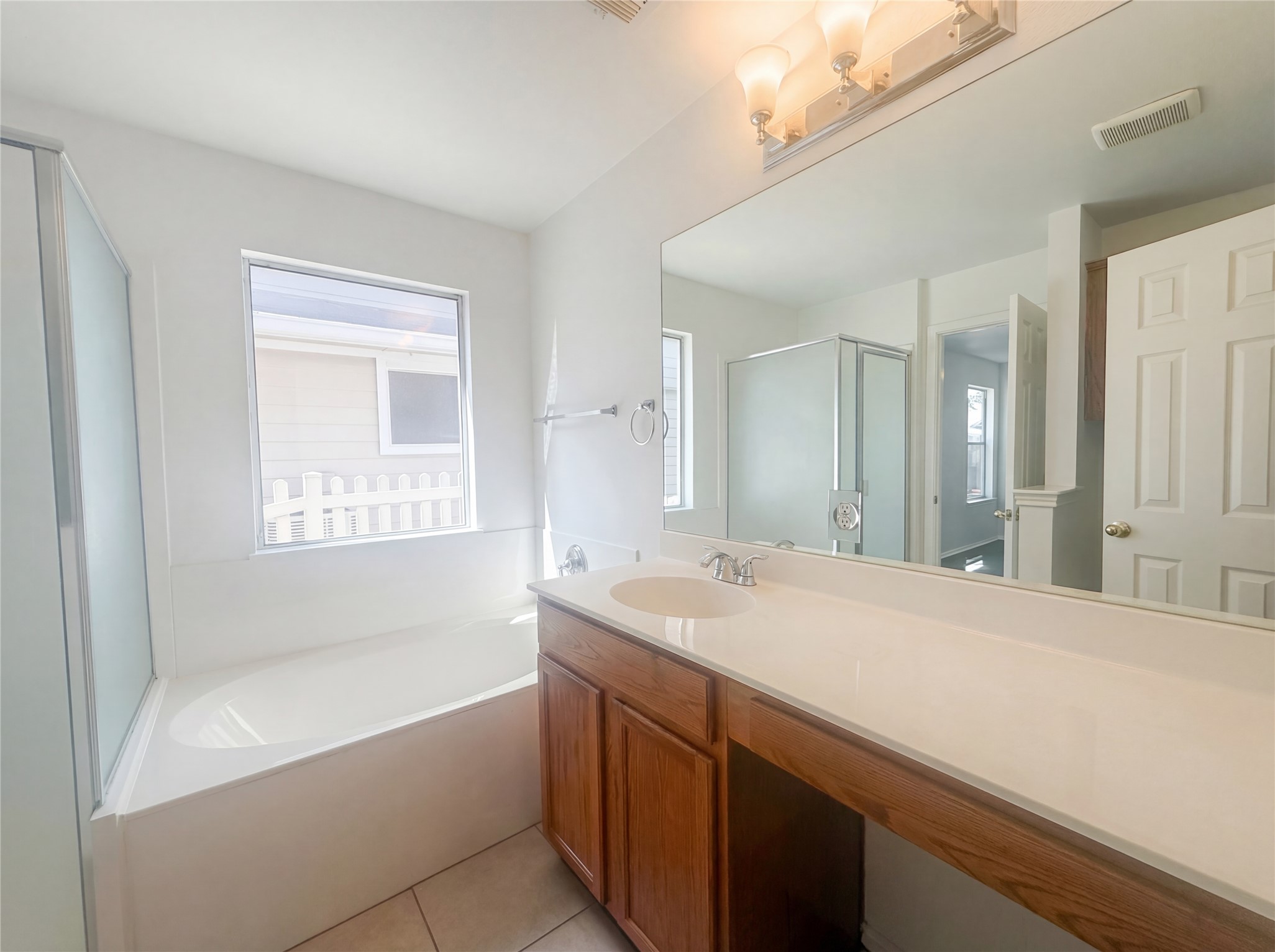 110 Strawn Kyle, TX 78640 - Photo 12 of 22 Full bathroom featuring vanity, a bath, a shower stall, and light tile patterned floors
