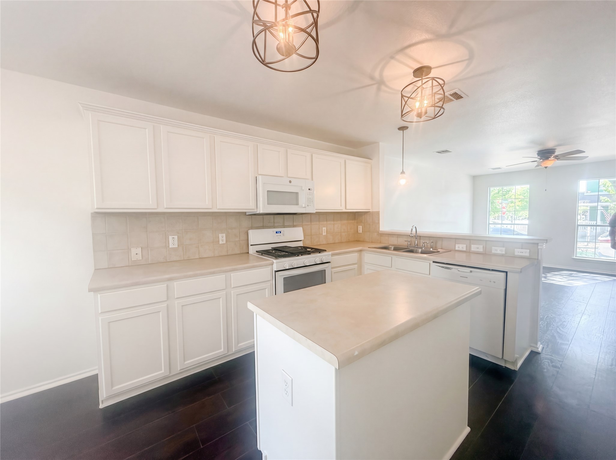 110 Strawn Kyle, TX 78640 - Photo 14 of 22 Kitchen with white appliances, white cabinetry, light countertops, decorative backsplash, and dark wood-style flooring
