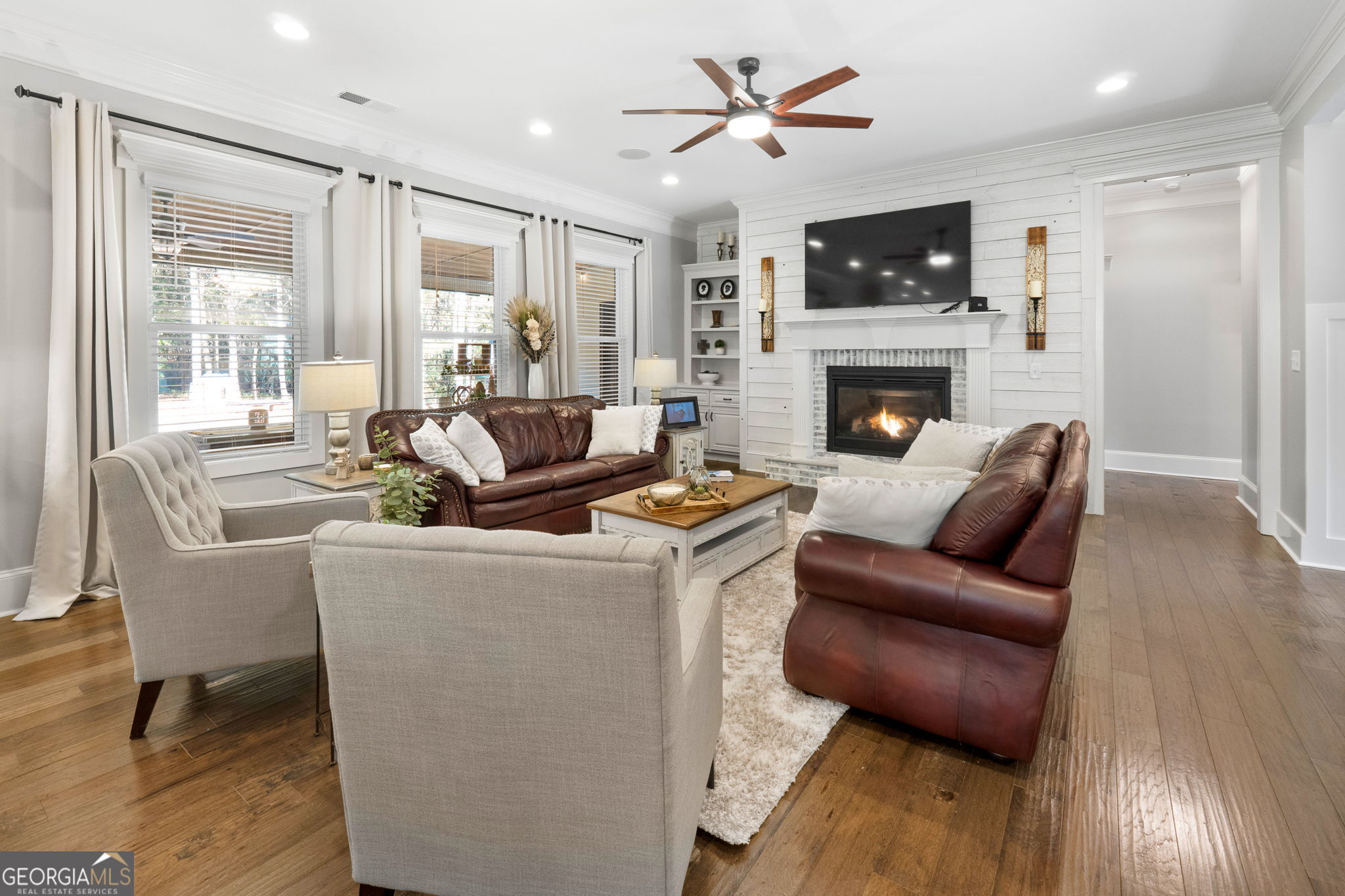 173 Dolly Nixon Road Senoia, GA 30276 - Photo 32 of 105 a living room with furniture a fireplace and a flat screen tv