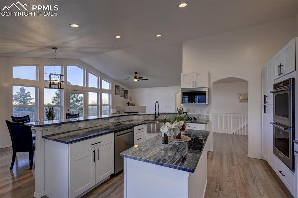 7790 Julynn Road Colorado Springs, CO 80919 - Photo 16 of 50 a kitchen with stainless steel appliances granite countertop a sink stove and cabinets