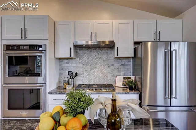 a kitchen with stainless steel appliances a stove refrigerator sink and cabinets
