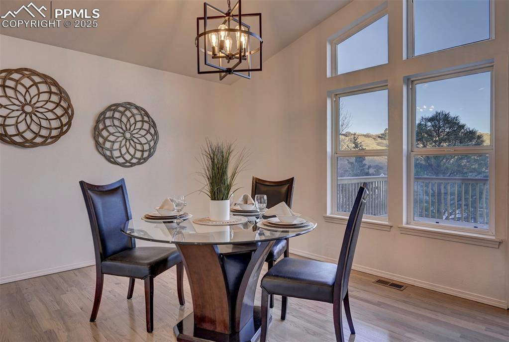 7790 Julynn Road Colorado Springs, CO 80919 - Photo 20 of 50 a view of a dining room with furniture wooden floor and a chandelier