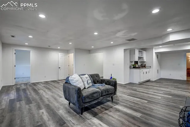 a living room with furniture and a wooden floor