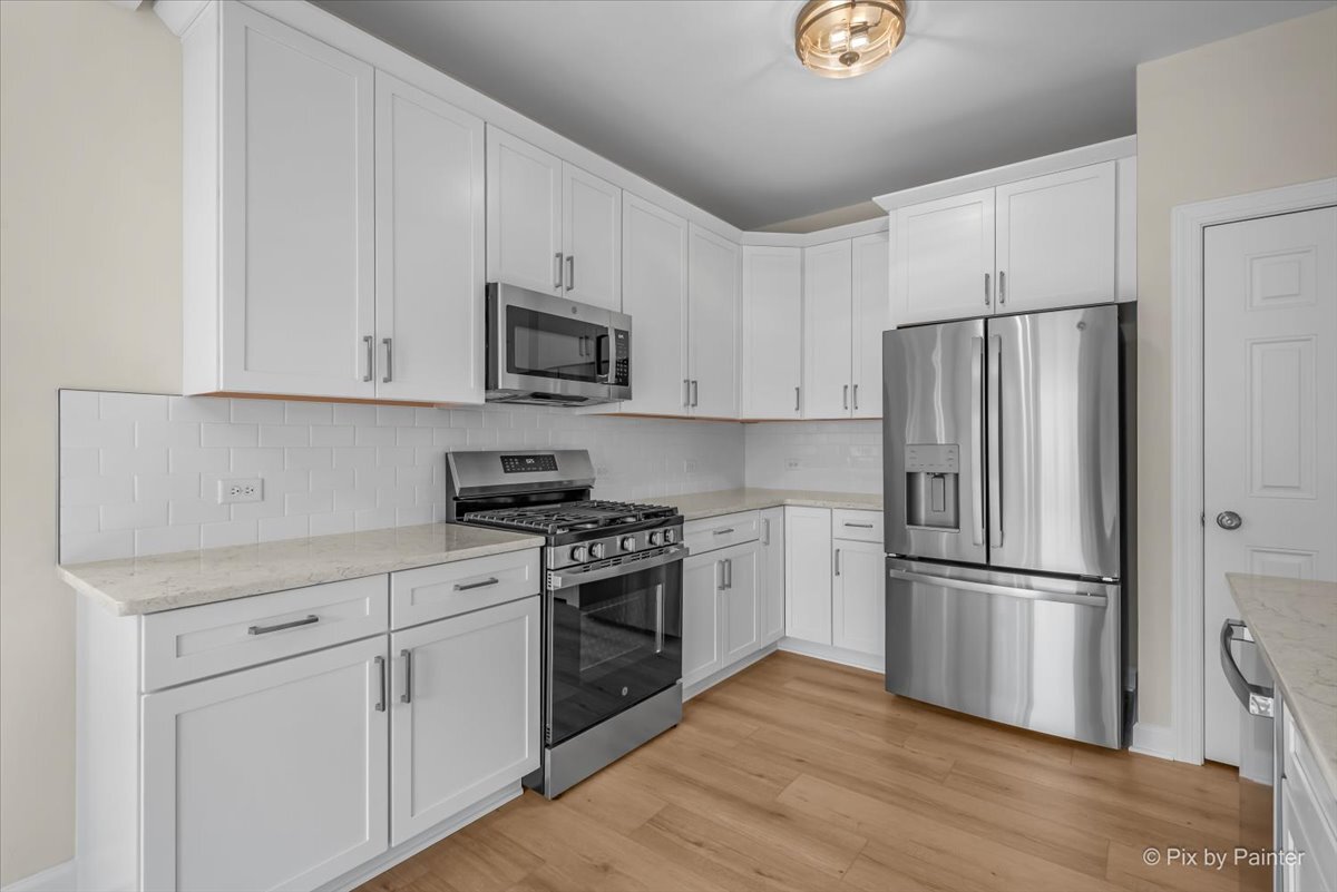 216 Winding Trail Genoa, IL 60135 - Photo 14 of 52 a kitchen with cabinets stainless steel appliances and wooden floor
