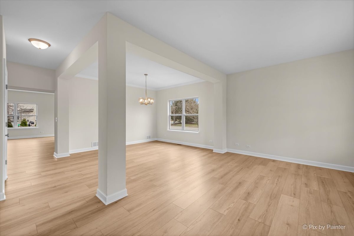 216 Winding Trail Genoa, IL 60135 - Photo 7 of 52 a view of an empty room with wooden floor and a window