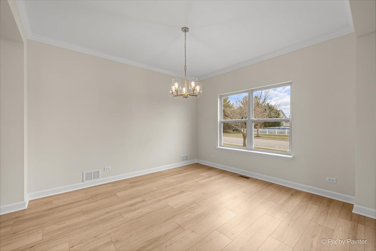 216 Winding Trail Genoa, IL 60135 - Photo 8 of 52 an empty room with wooden floor chandelier and windows
