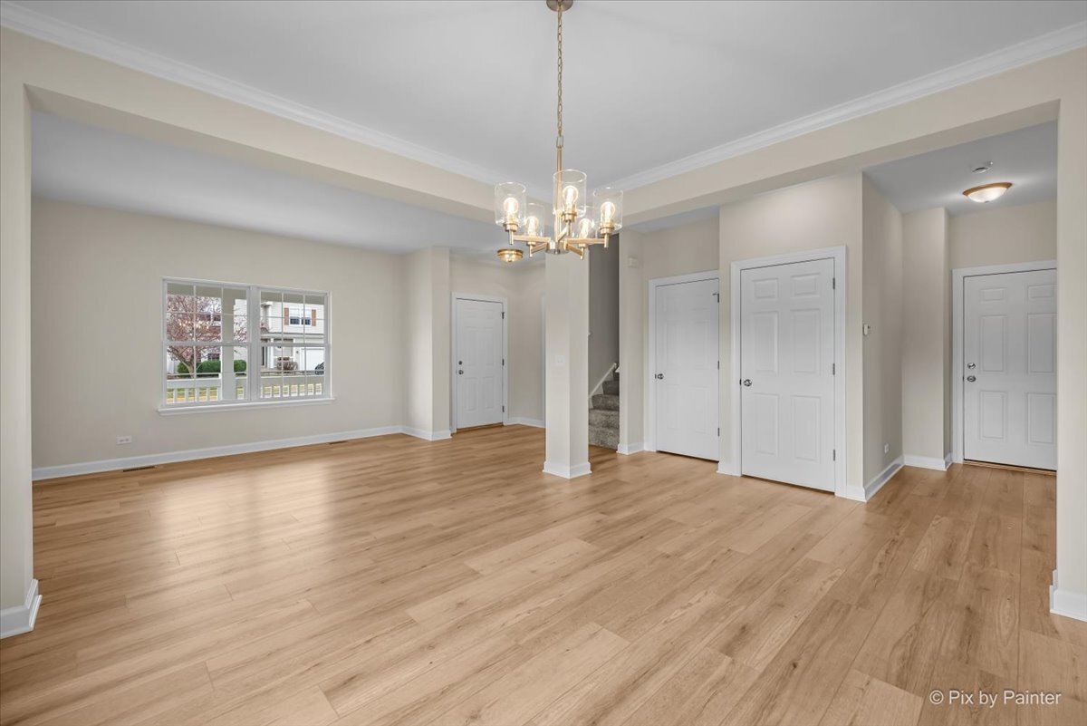 216 Winding Trail Genoa, IL 60135 - Photo 9 of 52 a view of a hallway with wooden floor and a chandelier