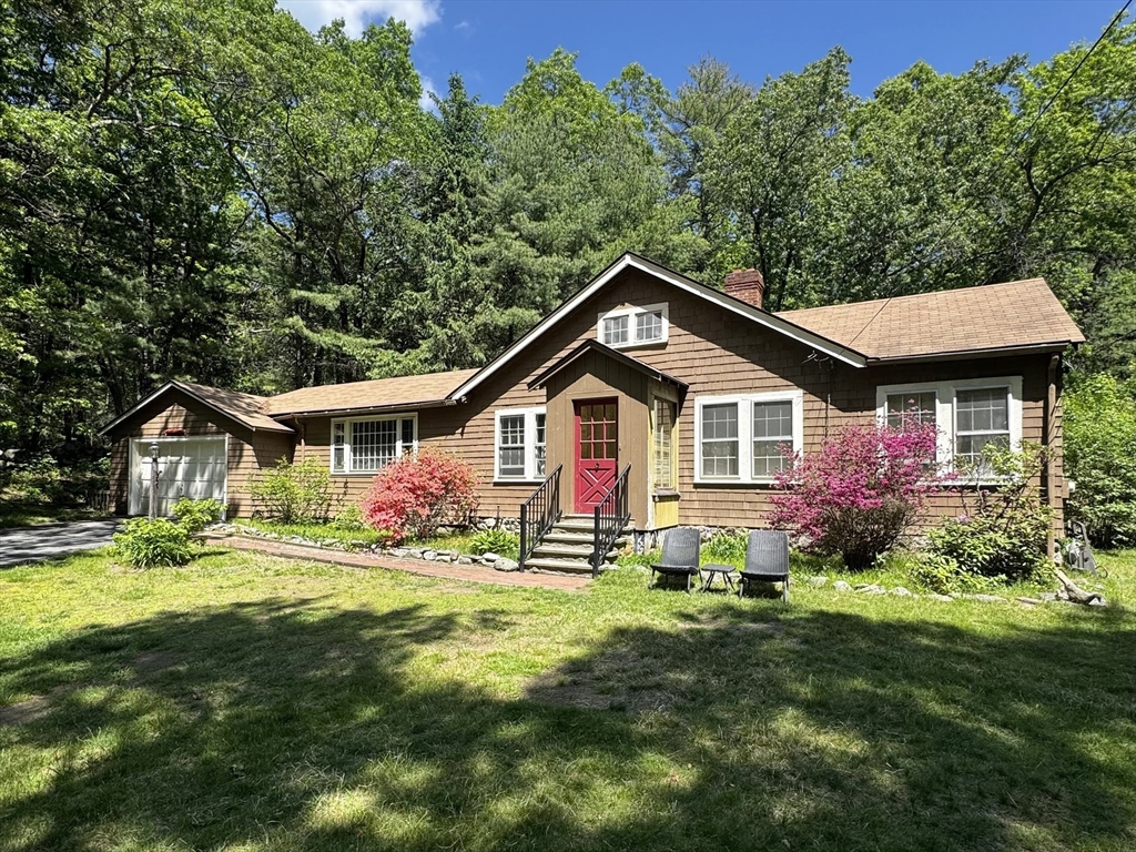 a front view of a house with a yard and trees