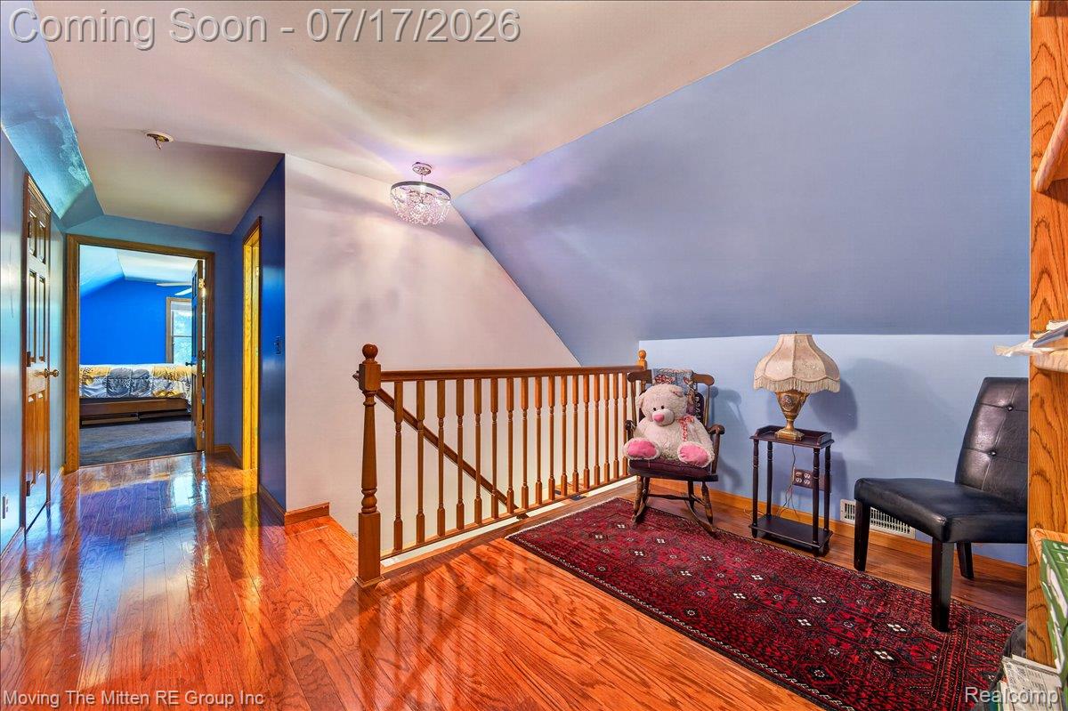 40162 Alden Road Belleville, MI 48111 - Photo 29 of 67 Attic space featuring wood-finish flooring, a wood balustrade, and a contemporary ceiling light fixture