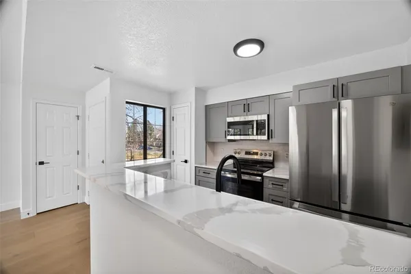 a kitchen with stainless steel appliances a refrigerator and a stove top oven