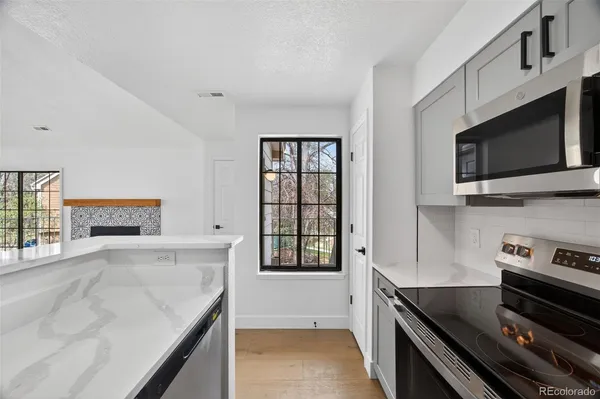 a kitchen with stainless steel appliances granite countertop a stove and a microwave
