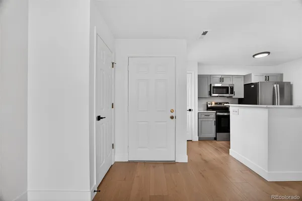 a view of a kitchen with refrigerator and white cabinets