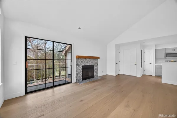 a view of an empty room with a fireplace and a window