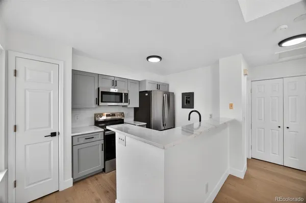 a kitchen with stainless steel appliances granite countertop a refrigerator and a stove top oven