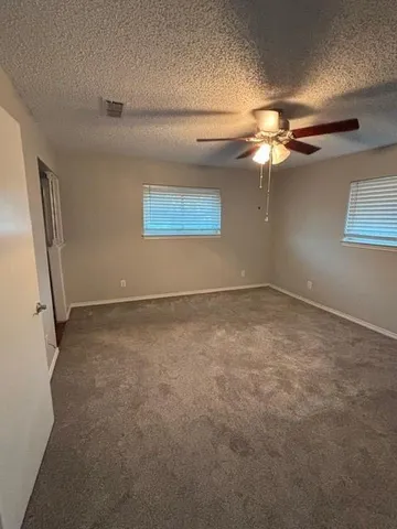 en empty room with windows and fan