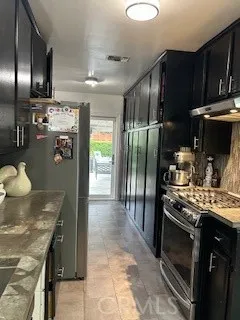 a kitchen with stainless steel appliances granite countertop a stove refrigerator and cabinets