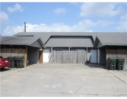 a view of a house with a barbeque and large trees