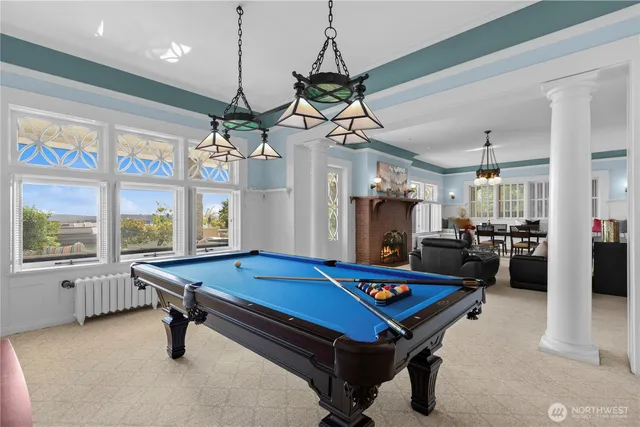 a living room with pool table and windows