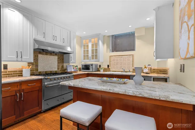 a kitchen with stainless steel appliances granite countertop a sink stove and cabinets