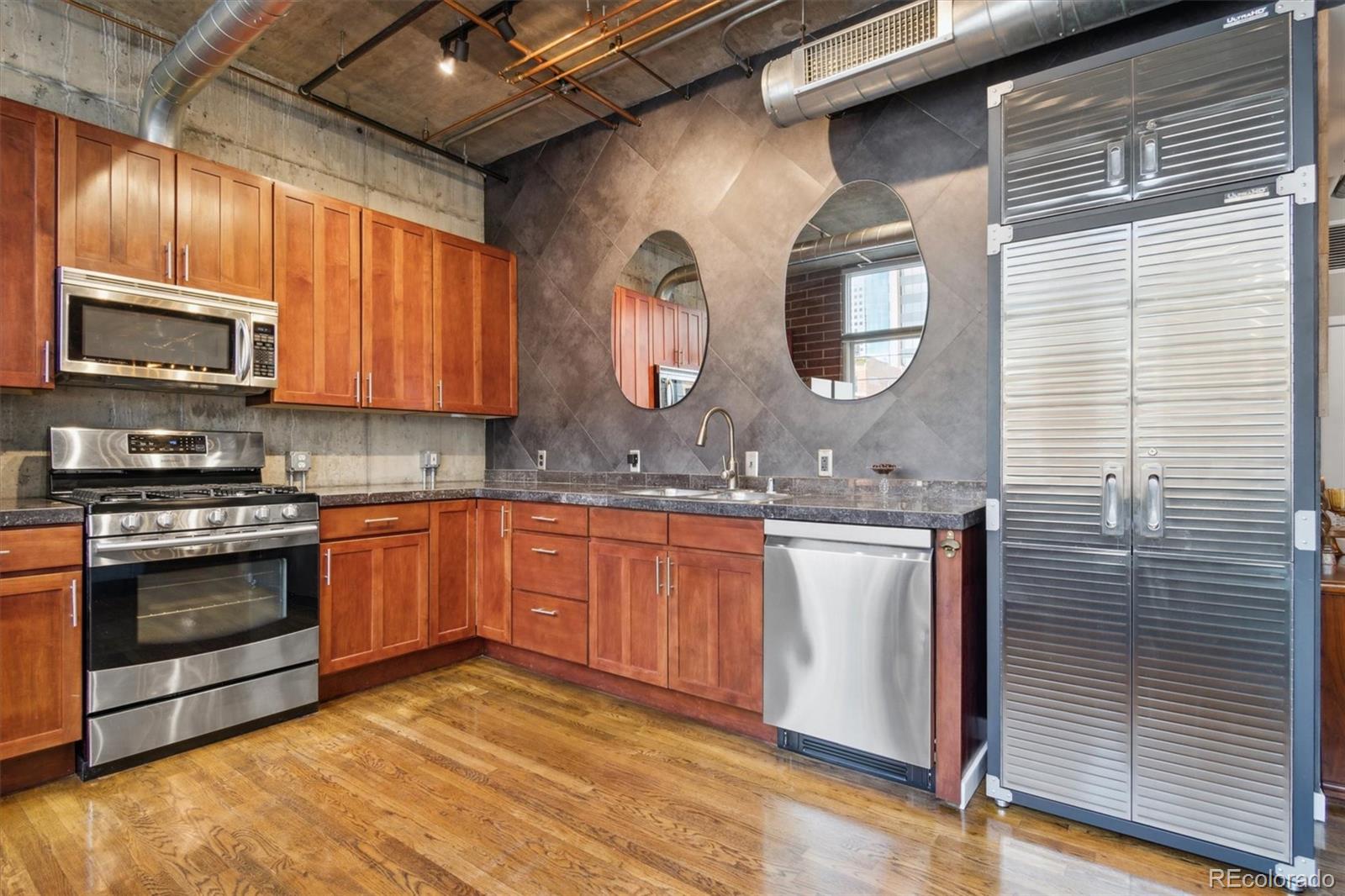 1720 Wazee Street, Unit 2B Denver, CO 80202 - Photo 12 of 17 a kitchen with stainless steel appliances granite countertop a stove a sink and a microwave