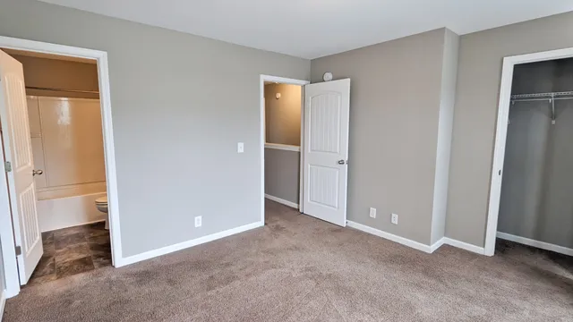 an empty room with closet and a bathroom